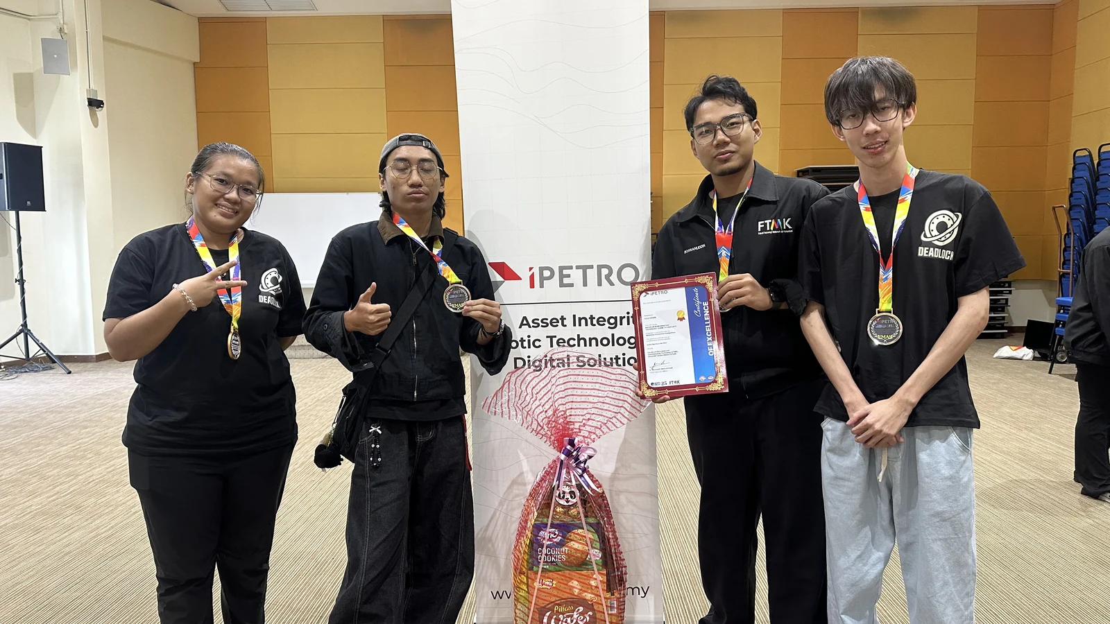 Team DEADLOCK holding medals and the iPETRO Gold Award certificate
